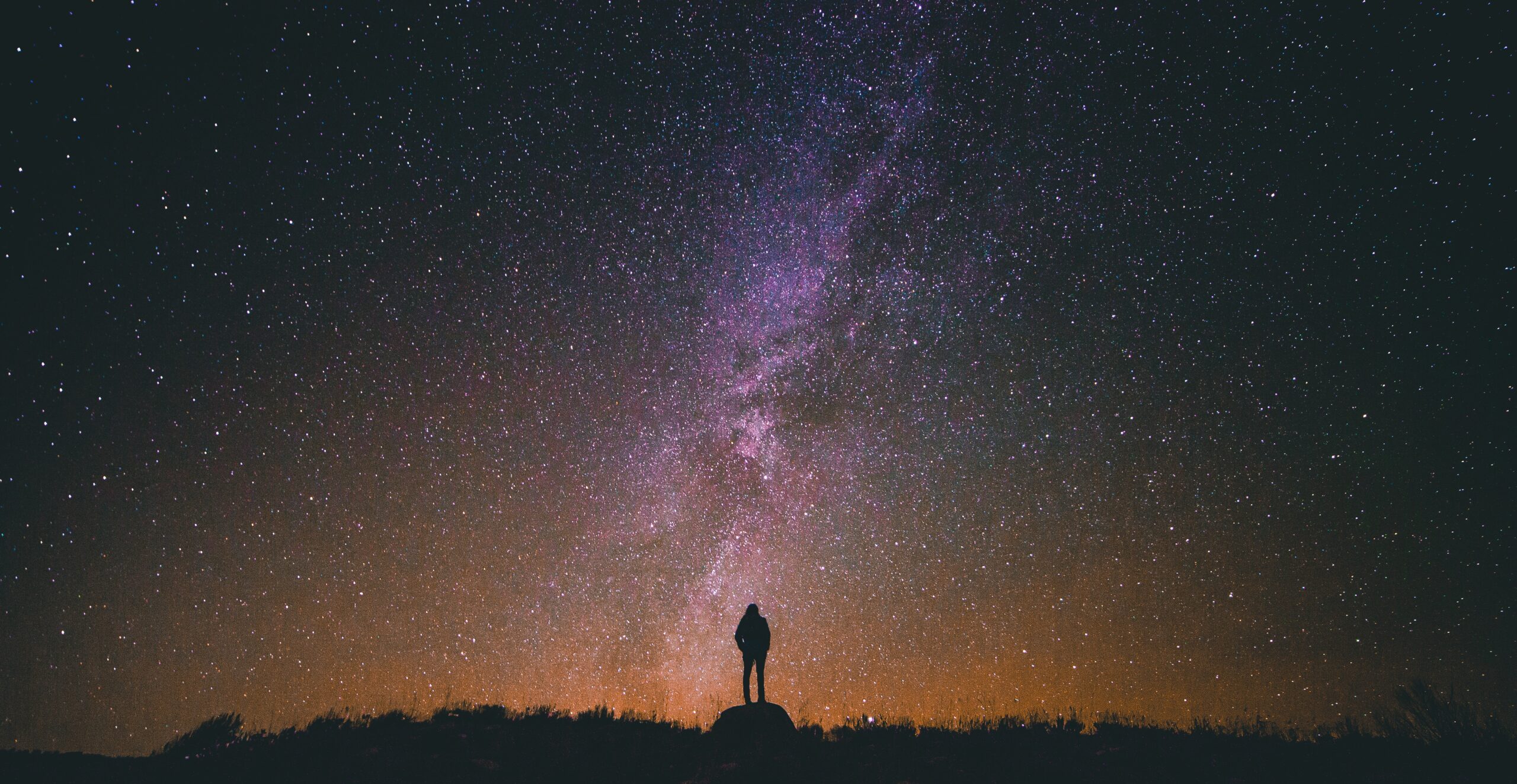 Humano mirando al horizonte estrellado